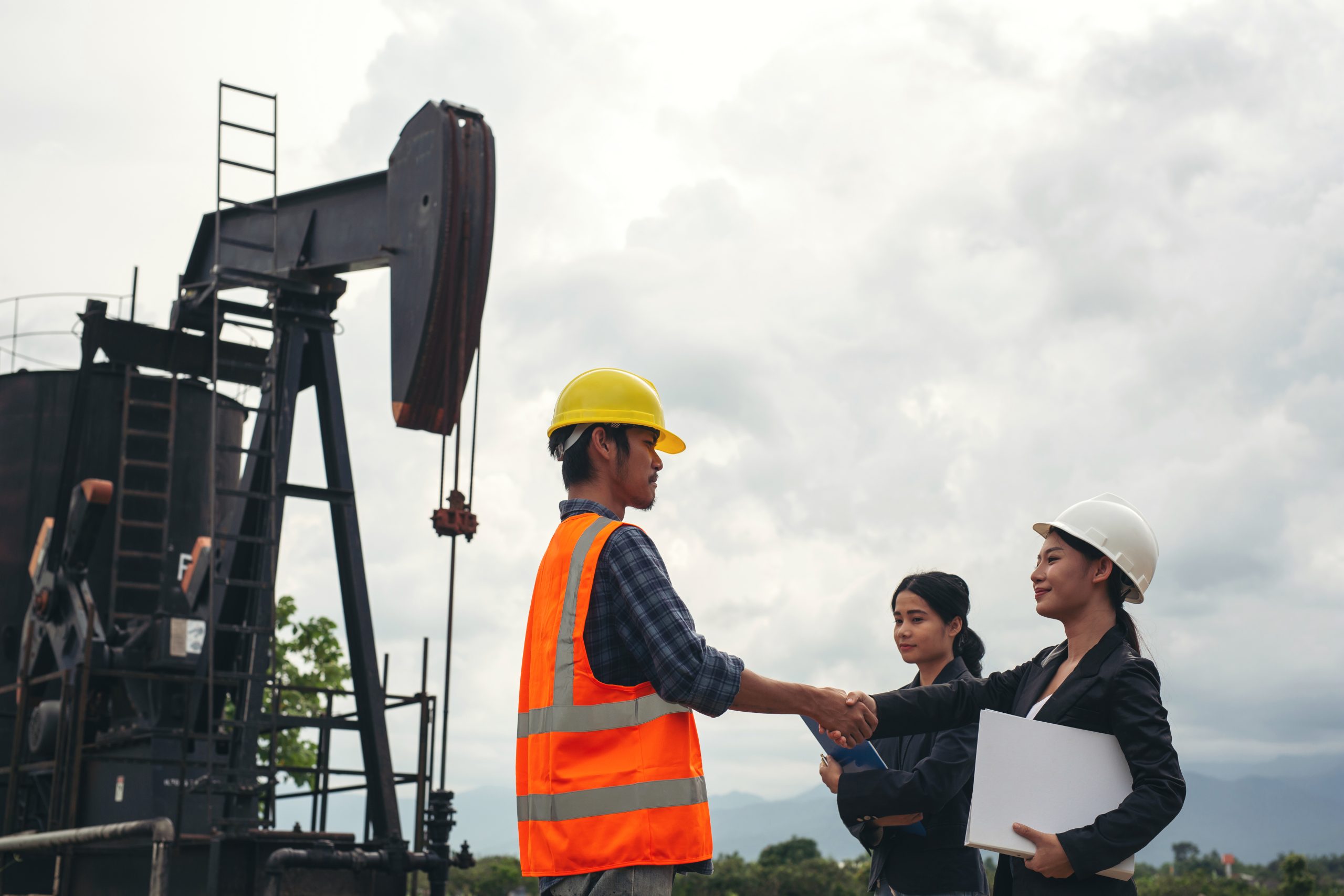 Engineering team beside oil pumps